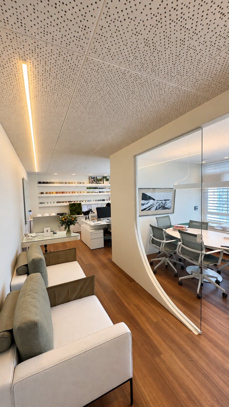 Sala de estar do ateliê MUSGO, com poltronas e vista para a sala de reuniões